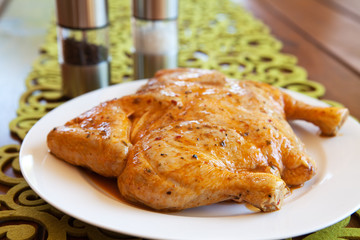 Uncooked whole chicken on a white plate