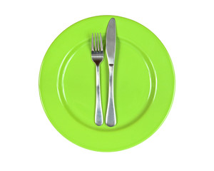 Fork and knife on green plate isolated on white