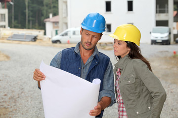 Team of architects checking plans on site