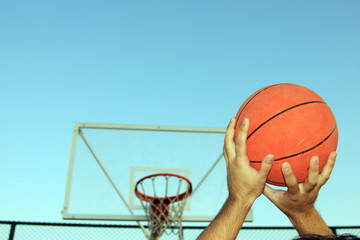 The player while throwing basket ball to basketball ring