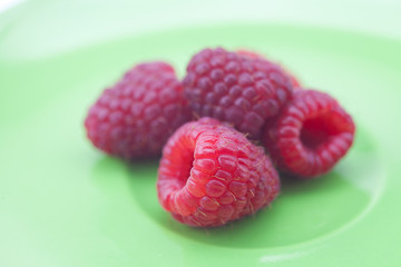 raspberries lying on a green plate