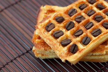 coffee beans and waffles on a bamboo mat