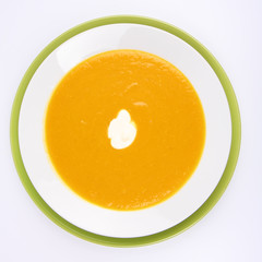 Pumpkin Soup decorated with cream on white background