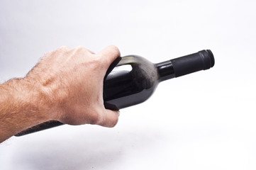 Hand holding a dusty bottle of red wine
