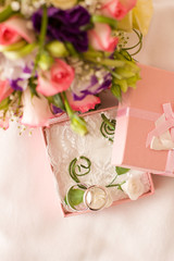 Fototapeta na wymiar Close up of wedding rings. Bridal bouquet in background