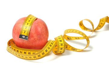 Red apple and measure tape over white