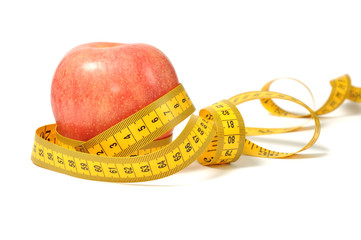 Red apple and measure tape over white