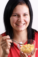 eine junge Frau isst Corn flakes