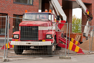 Old red platform lifter truck on construction site