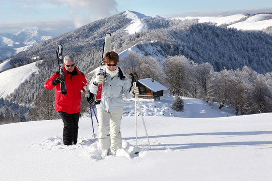 Homme et femme seniors marchant dans la neige