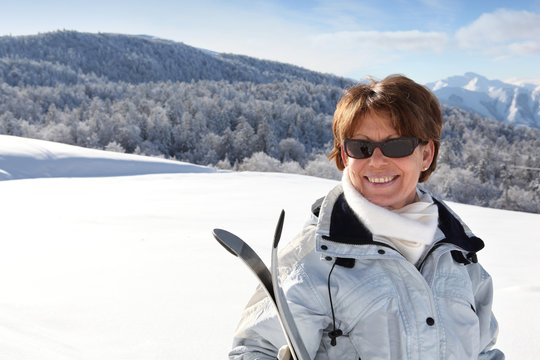 Portrait d'une femme senior souriante à la neige
