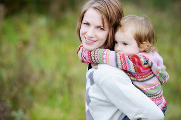 A girl having a piggyback ride on her mom