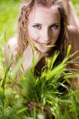 Fototapeta premium A beautiful model lies amid tall grass