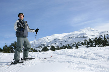 Fototapeta na wymiar Jeune homme sur des skis à la neige