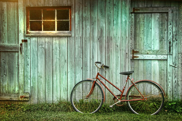 Old bicycle leaning against grungy barn