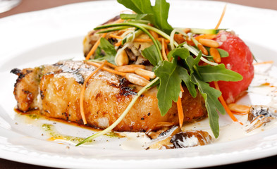 Grilled pork steak with vegetable garnish.