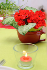 candle in a glass candlestick and flowers