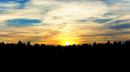 Fototapeta premium Dramatic sunset over forest