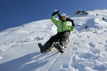 Fototapeta na wymiar Jeune femme faisant de la luge à la neige