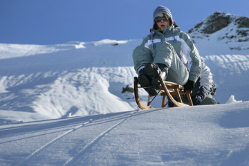 Fototapeta na wymiar Jeune femme faisant de la luge à la neige