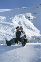 Fototapeta na wymiar Groupe d'amis assis sur une luge à la neige