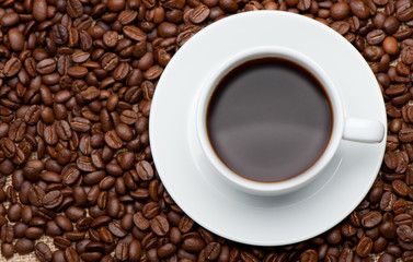 Cup of coffee on coffee grains