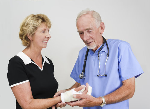 Doctor Attending Old Woman With Hand In Cast