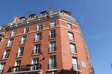 Fototapeta na wymiar Immeuble en briques rouges du quartier du Montparnasse à Paris