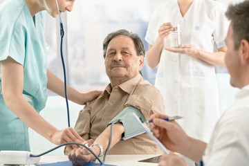 Patient getting blood pressure measurement - Powered by Adobe