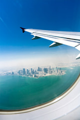 Bird's eye view on the modern city under the plane wing