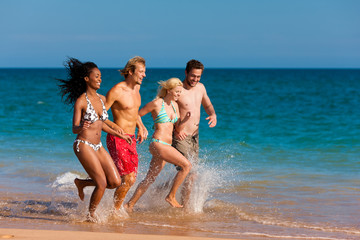 Friends running on beach vacation