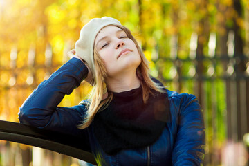 Beautiful young woman relaxing in autumn park