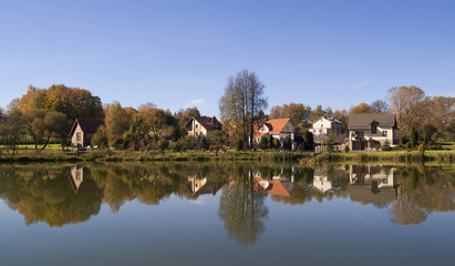 Obraz premium Small village and its reflection in water