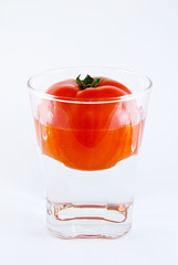 tomato in a glass of water isolated on white background