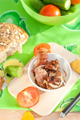 Grilled meat with vegetables and bread over the green tablecloth