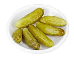Some pickled cucumbers in white plate isolated