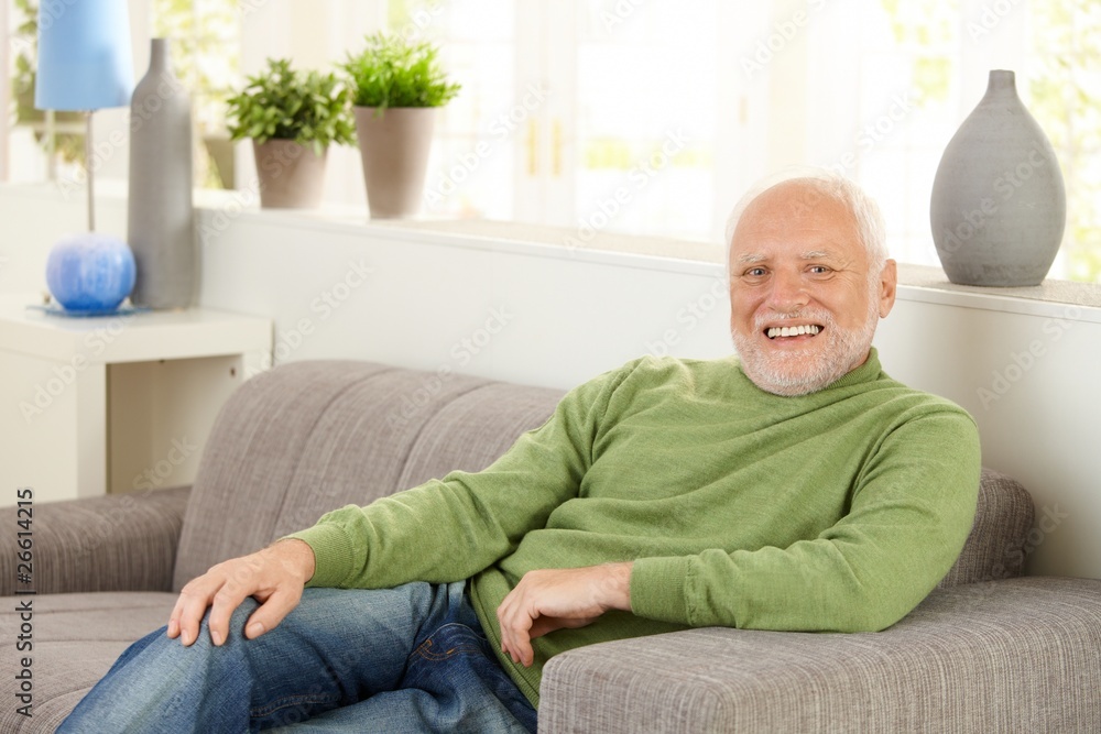 Wall mural Portrait of happy senior on sofa