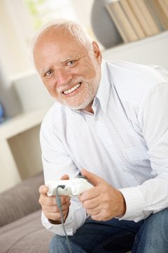 Portrait of modern senior playing computer game
