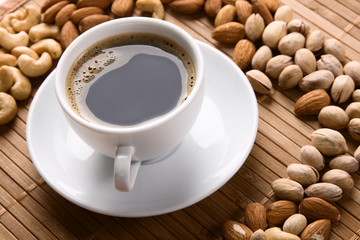White cup of coffee with lot of nuts