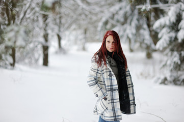 Fototapeta na wymiar Young woman having a walk in winter forest