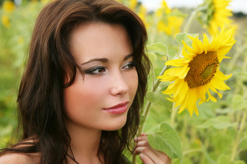 Naklejka premium The young woman with sunflowers.