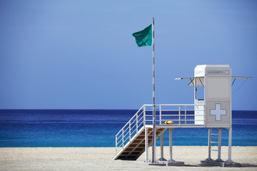 Rettungsturm am Strand mit grüner Fahne