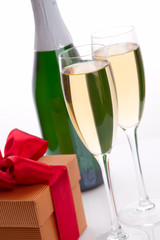 Glasses of champagne with red ribbon gifts.