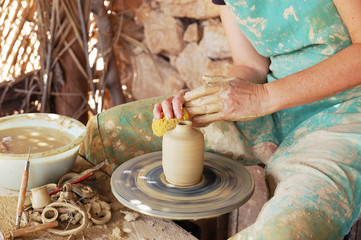 close up of the hands of a potter creating a jug