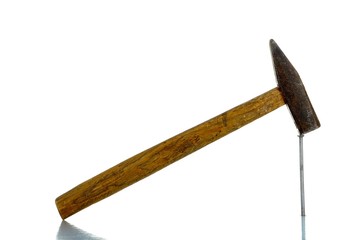 rusty old hammer with nail and reflection - isolated on white