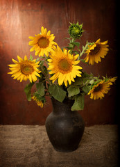 Naklejka premium sunflowers in a clay pot. still life
