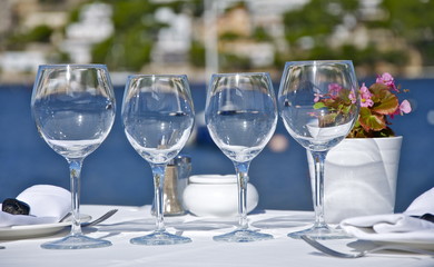 Gläser auf festlich geschmücktem Tisch vor Meerehintergrund