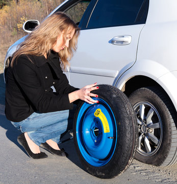 Woman changing the wheel