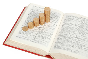 Coins with book on white background