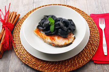 ravioli al nero di seppia con filetto di salmone